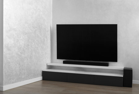 Part of the interior of the living room with a TV on the wall, hifi equipment, Sound bar, gray cabinet. TV and music system in the interior. Modern living room in bright colors.の写真素材
