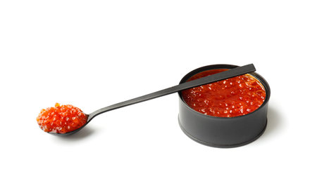 Red salmon caviar in a black tin can and in a black decorative spoon on a white background. Useful delicacy seafood, canned fish.の写真素材