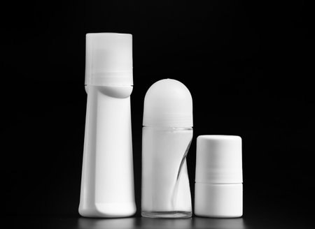 Set of white antiperspirant deodorant roll-on, isolated on black background, mockups of white plastic packaging for personal hygiene, containers with a lid to protect the skin from sweat and odor.の写真素材
