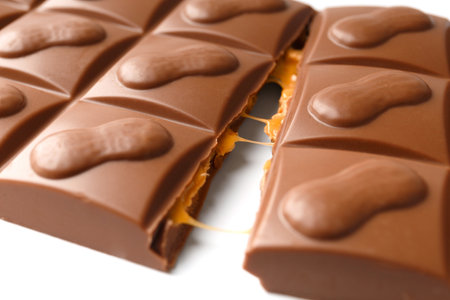 broken milk chocolate bar with nuts on a white background close upの写真素材