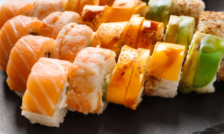 Set roll with salmon, avocado, shrimp and eel on a stone board on a gray background, close-upの写真素材