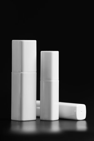 Set of white plastic bottles for face skin care cosmetics, isolated on black background. Packaging...
