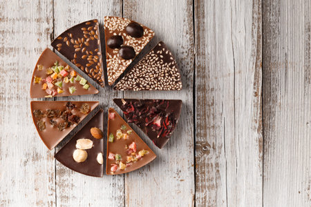 Creative composition chocolate in the shape of a pizza with candied fruits, nuts, dry berries,...
