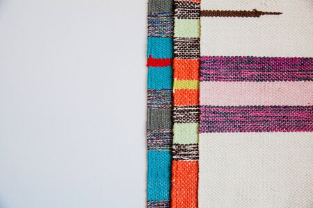 Several brightly colored striped textile mats on a white background. Colorful textile texture with space for text. Flat lay.の写真素材