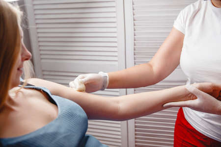 the master of sugaring puts paste on the clients hand in the salonの写真素材