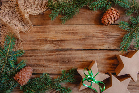 Christmas Flat lay of fir branches, cones, craft boxes in the star shape and burlap on a wooden...
