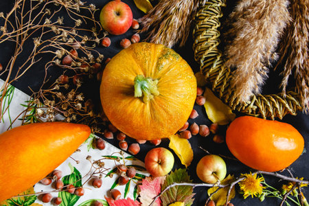 Autumn composition on the table of textile, pumpkins, apples, nuts and dried flowers. Flat lay. High...