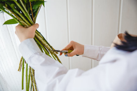 The process of pruning the stems of a bouquet with pruning shears in a flower shop.