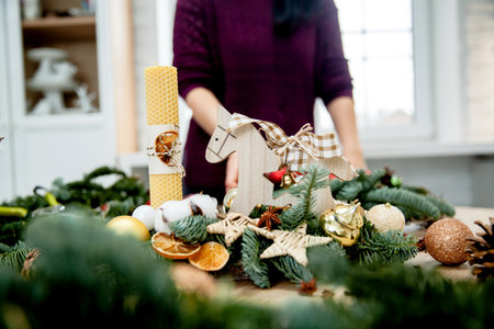 Christmas decorations in the form of a candle, a wooden horse, dried citrus and spruce branches on...