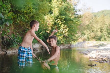 Childrens playing and splashing in the mountain riverの写真素材