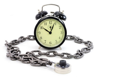 alarm clock  and chain with white background, concept of time freezeの写真素材