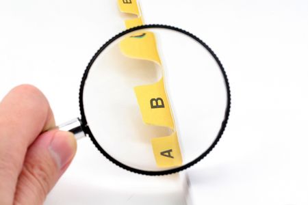 yellow file divider and magnifier, office supplies, close upの写真素材