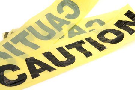 yellow plastic caution tape with white backgroundの写真素材