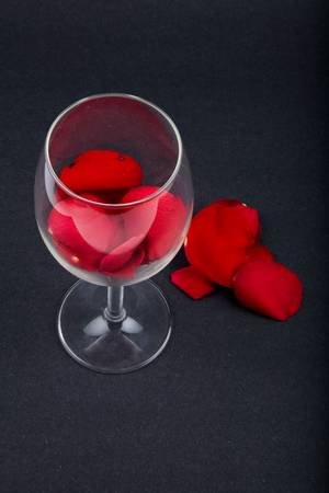 rose petals in a wine glass with black background, love conceptの写真素材