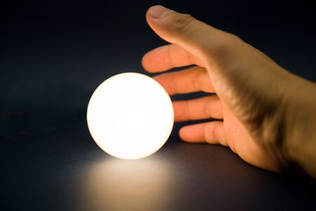 Hand touching a bright ball, Concept of magicの写真素材