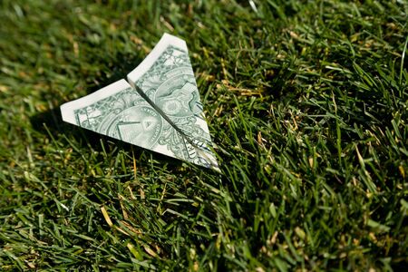 US Dollar Airplane and green grass, concept of Environmental Conservationの写真素材