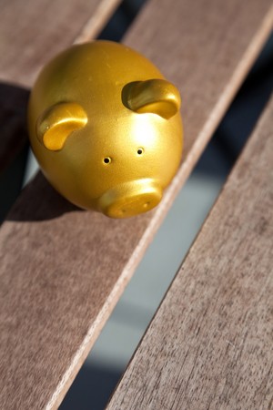 Gold Piggy Bank on wood table topの写真素材