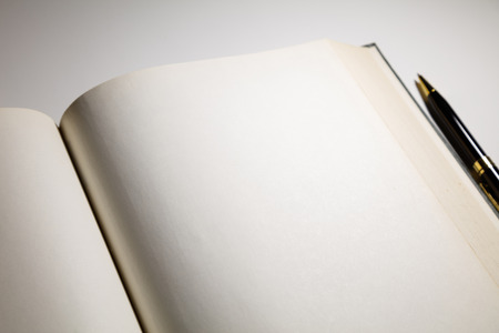 Blank pages in an open book with a penの写真素材