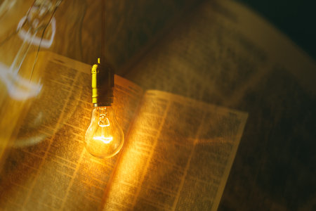 electric bulb illuminating a bookの写真素材