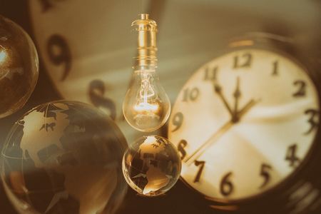 Light bulb, earth and clock, concept of global issuesの写真素材