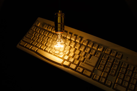 Light bulb and computer keyboard, concept of wisdom.の写真素材