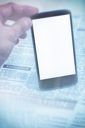 Fake newspaper and smartphone with blank screen. business communication concept.の写真素材