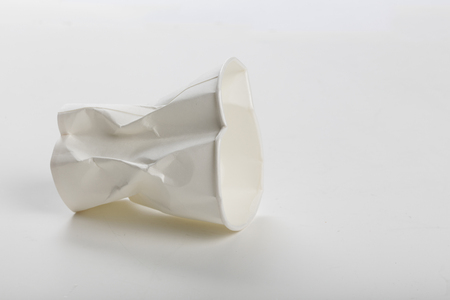 Crumbled White paper coffee cup on white background.の写真素材