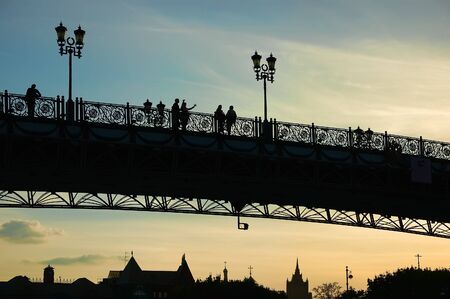 People silhouettes on bridge at sunsetの写真素材