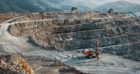 Industrial landscape with red stone crusher machine in gravel quarry