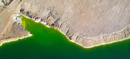 Shore of toxic green lake in abandoned open pit copper mine. its color derives from high levels of acid and heavy metals. Aerial panorama from directly aboveの写真素材