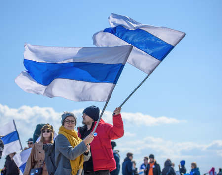 LIMASSOL, CYPRUS - MARCH 13, 2022: Two protesters on a rally against Russian invasion of Ukraine hold white-blue-white flags, a symbol of anti-war protests in Russiaのeditorial素材