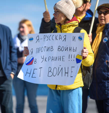 LIMASSOL, CYPRUS - MARCH 13, 2022: Female activist protest against Russian invasion of Ukraine holding sign âIâm Russian and Iâm against war in Ukraine!!! No to war!âのeditorial素材