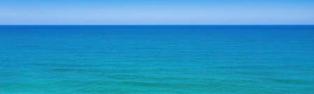 Seascape minimal panoramic background. Clear sky, horizon over blue wavesの写真素材