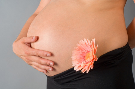The pregnant woman on the ninth month of pregnancy, in expectation of a small miracle, touches with a hand a stomach.の写真素材