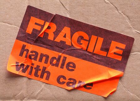 Fragile Sticker on Bent Up Box Isolated on a White Background.の写真素材