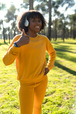 A girl dressed in yellow tracksuit stretching before starting a run in the park.の写真素材