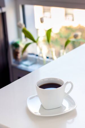 White cup of coffee on the white table in kitchen.の写真素材