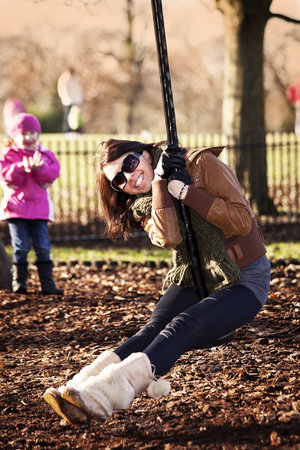 happy girl swinging on the swing in the parkの写真素材