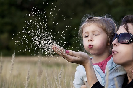 Mother explains to daughter haw is reproducing the grassの写真素材