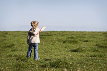 little girl pointing something in the horizontの写真素材