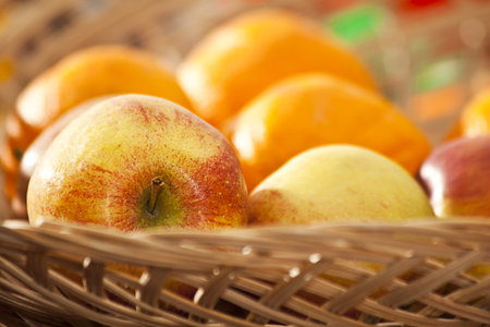 vicker basket with apples and orangesの写真素材