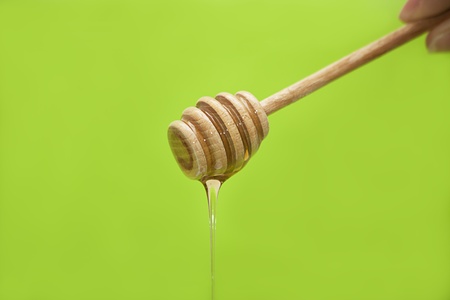 honey dripping from the wooden honey spoonの写真素材