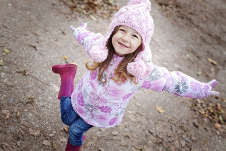 happy smiling girl in a wooly pink hat and winter jacketの写真素材