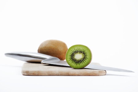 a sliced kiwi and a knife on a chopping boardの写真素材