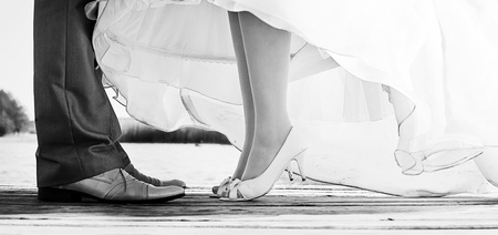 legs of bride and groom standing on a bridgeの写真素材