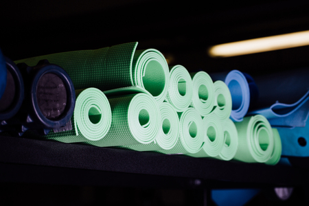 Many yoga mats green and blue colors on the shelf.の写真素材