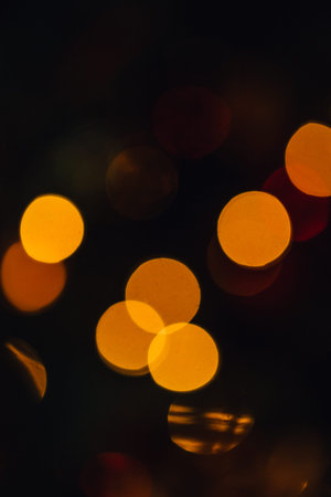 holidays, background and illumination concept - blurred golden christmas decoration or garland...