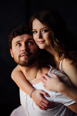 Happy couple of lovers in pajamas girl embracing man from behind. Smiling.の写真素材