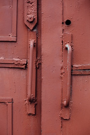 knob, handle A fragment of an old red iron door, the Soviet Russian Industrial factory, closeupの写真素材