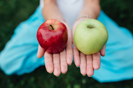 colorful picture of female hands with green and red apple.の写真素材